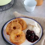 Frische Apfelküchle mit Beerenkompott und einer Kugel Vanilleeis.